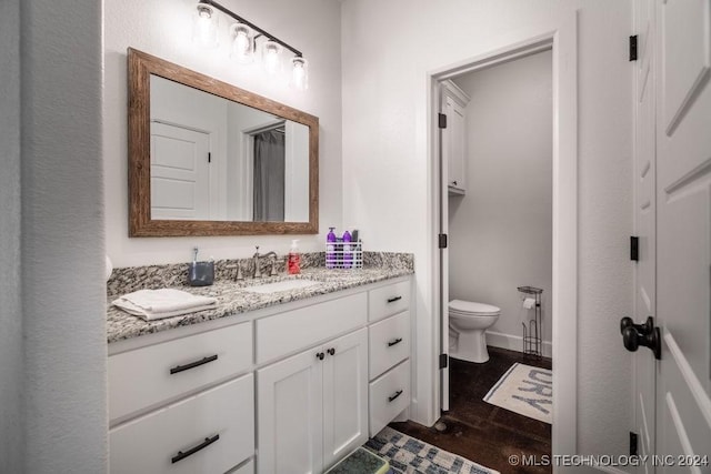 bathroom featuring hardwood / wood-style floors, vanity, and toilet