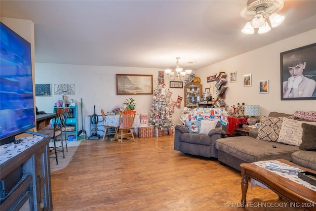 living room with hardwood / wood-style floors and ceiling fan with notable chandelier