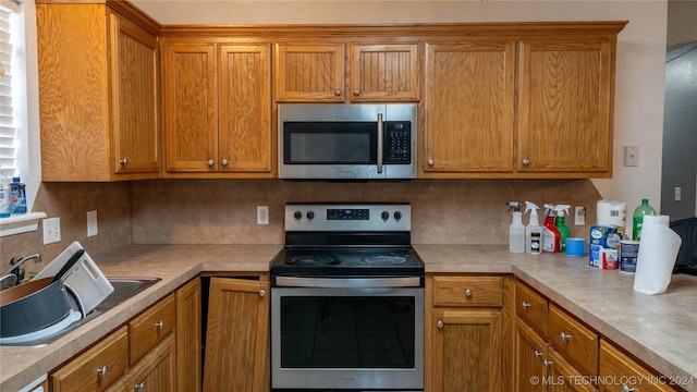 kitchen featuring decorative backsplash, sink, and appliances with stainless steel finishes