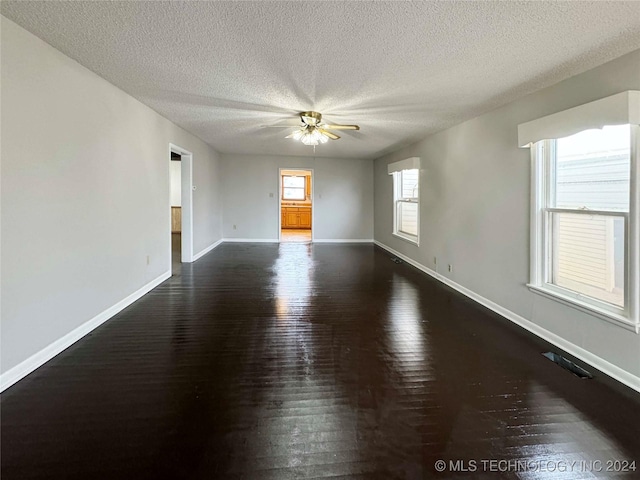 empty room featuring ceiling fan, dark hardwood / wood-style flooring, and a textured ceiling