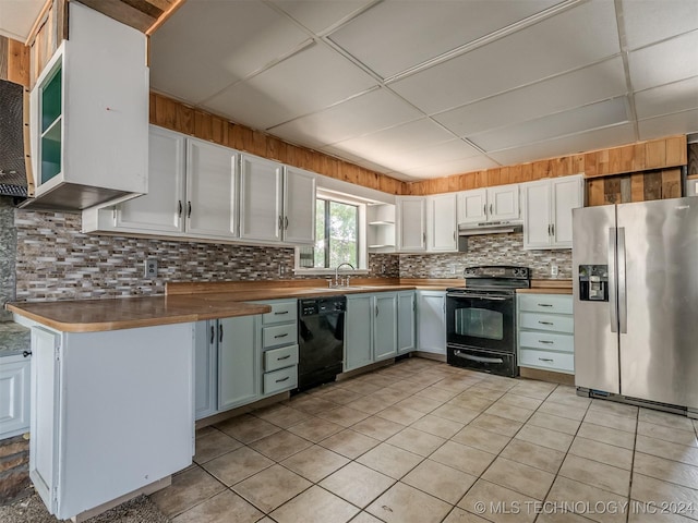 kitchen with light tile patterned flooring, wooden counters, white cabinets, and black appliances