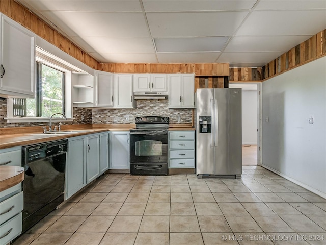 kitchen featuring butcher block countertops, a paneled ceiling, white cabinetry, and black appliances