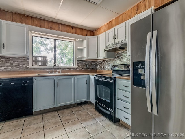 kitchen featuring black appliances, white cabinets, sink, light tile patterned floors, and tasteful backsplash