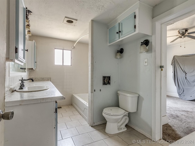 full bathroom with vanity, bathing tub / shower combination, ceiling fan, toilet, and a textured ceiling