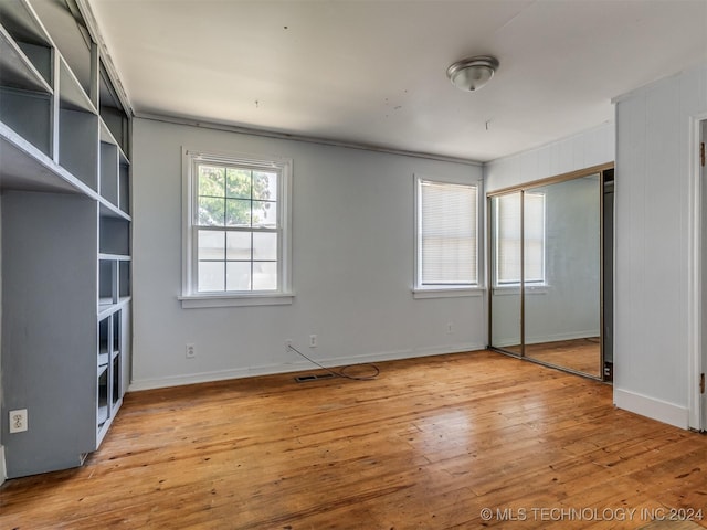 unfurnished bedroom with a closet and light hardwood / wood-style flooring