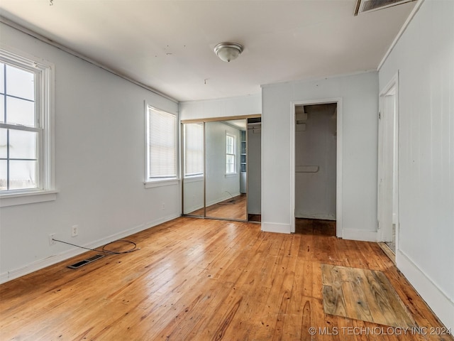 unfurnished bedroom with multiple windows and light hardwood / wood-style floors