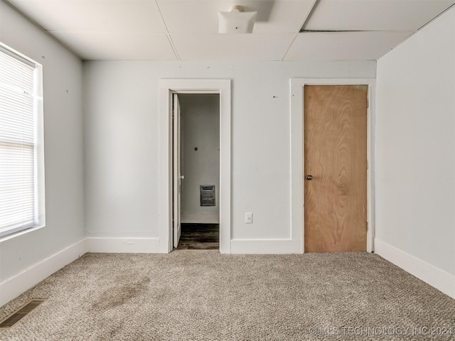 spare room with heating unit and carpet floors