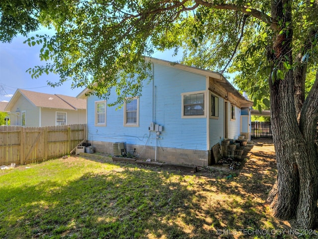 view of home's exterior featuring a yard and central AC unit