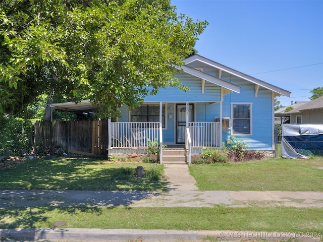 view of front of property featuring a front yard, a porch, and a carport