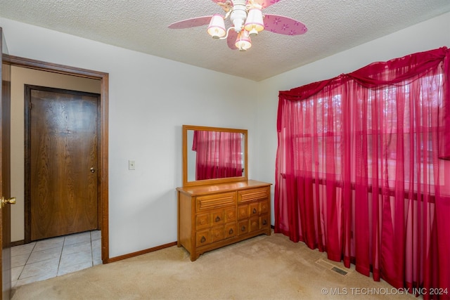 carpeted bedroom with ceiling fan and a textured ceiling