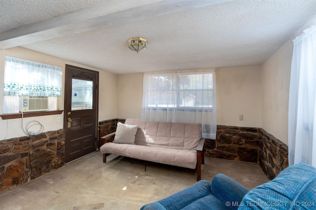 living room featuring cooling unit, a wealth of natural light, carpet floors, and a textured ceiling