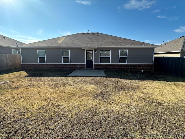 back of house featuring a lawn and a patio