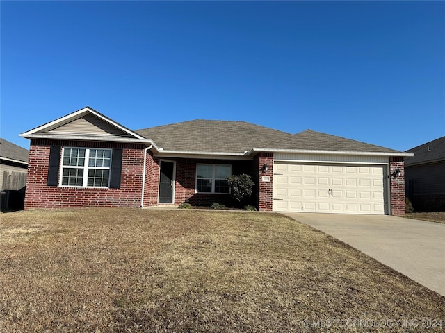 single story home featuring a garage and a front lawn