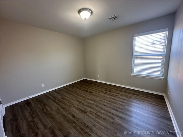 empty room with dark wood-type flooring