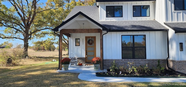 view of exterior entry featuring a lawn