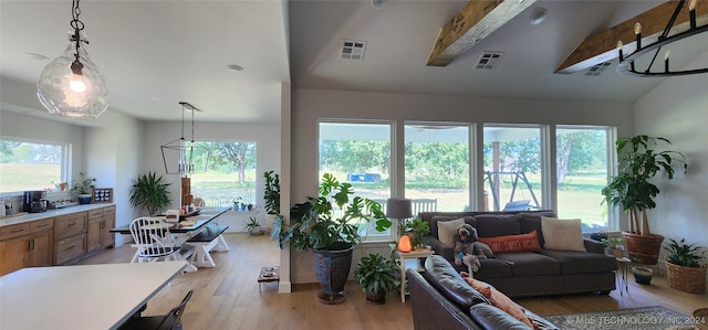 living room with vaulted ceiling with beams and light hardwood / wood-style flooring