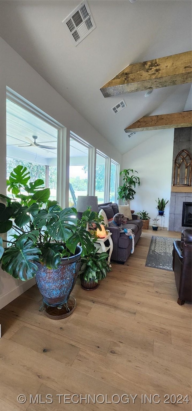 living room featuring vaulted ceiling with beams, light hardwood / wood-style floors, and ceiling fan