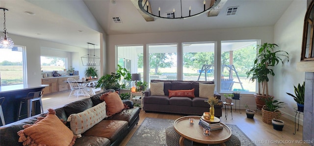 living room with a healthy amount of sunlight, a notable chandelier, and hardwood / wood-style floors