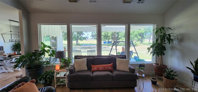 living room with a chandelier, a healthy amount of sunlight, and hardwood / wood-style flooring