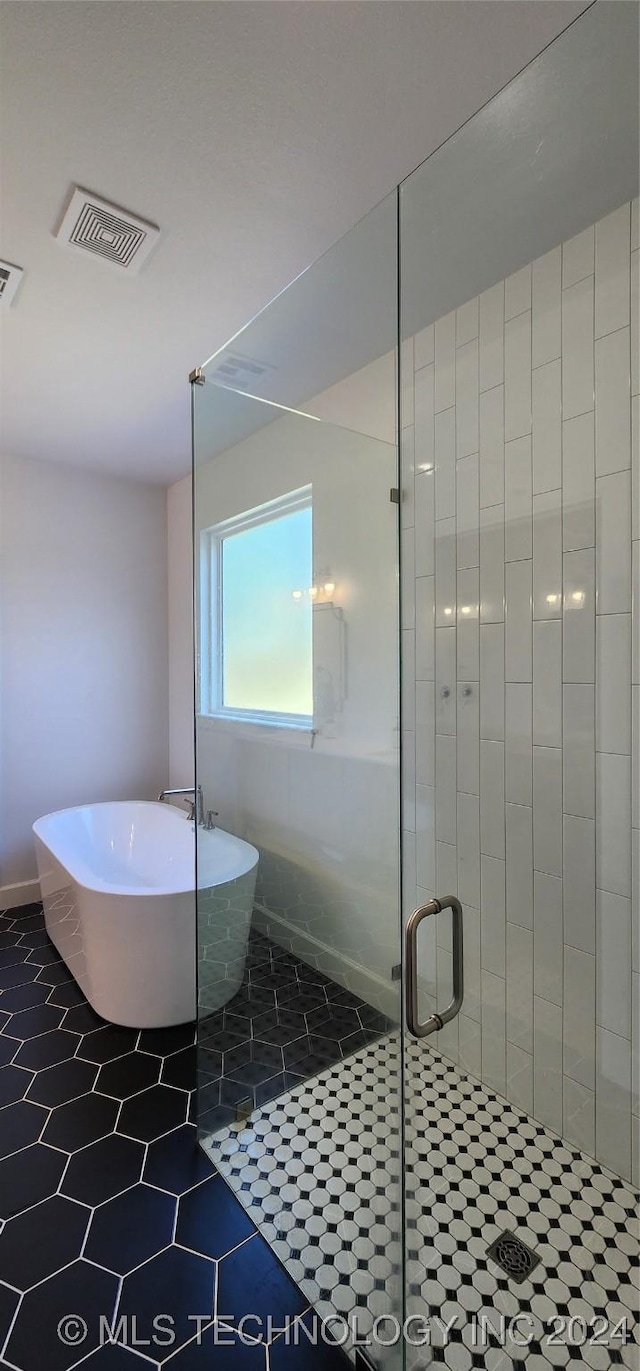 bathroom featuring tile patterned flooring and shower with separate bathtub