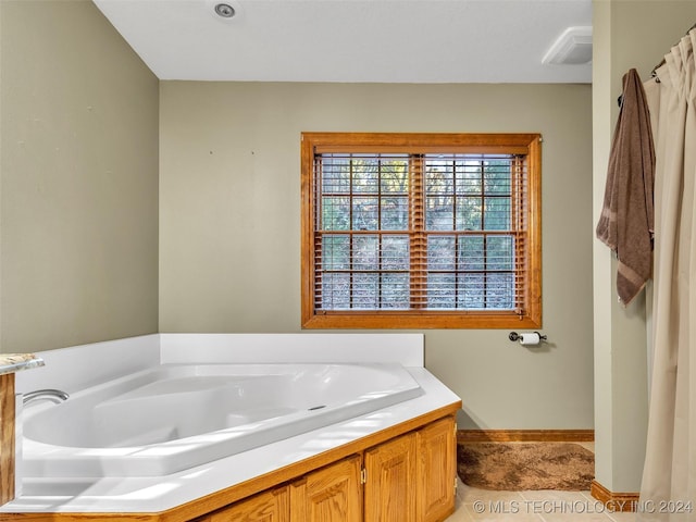 bathroom featuring tile patterned flooring and a tub to relax in