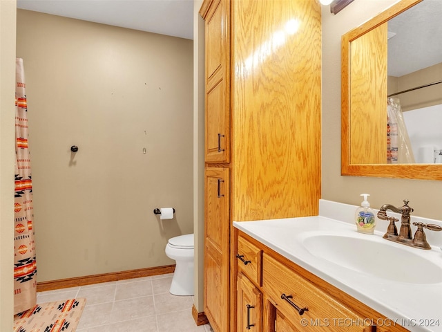 bathroom with tile patterned flooring, vanity, and toilet