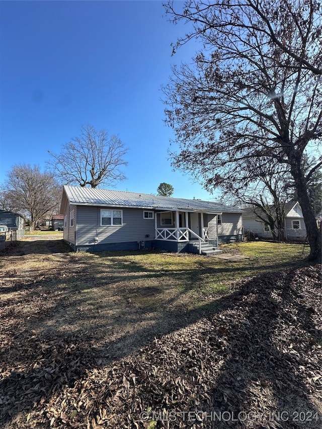 exterior space with covered porch and a front lawn