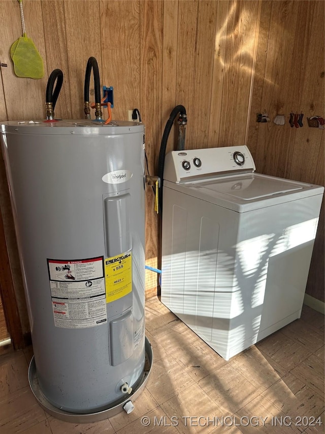 washroom featuring wooden walls, washer / clothes dryer, and electric water heater