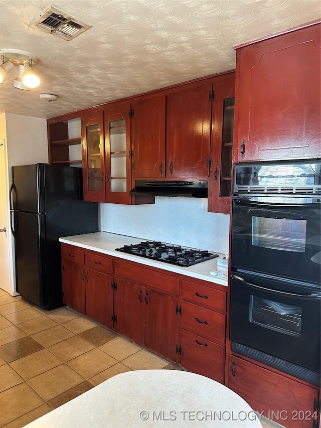 kitchen featuring a textured ceiling, light tile patterned floors, and black appliances