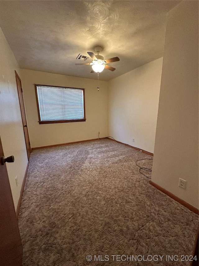 carpeted spare room featuring a textured ceiling and ceiling fan