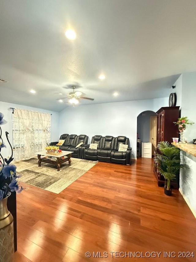 living room featuring wood-type flooring and ceiling fan