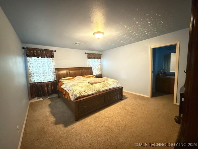 bedroom with carpet flooring and ensuite bath