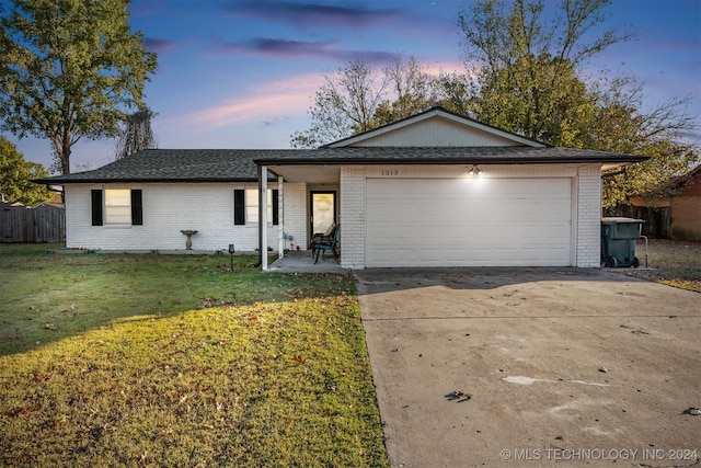 ranch-style house featuring a lawn and a garage