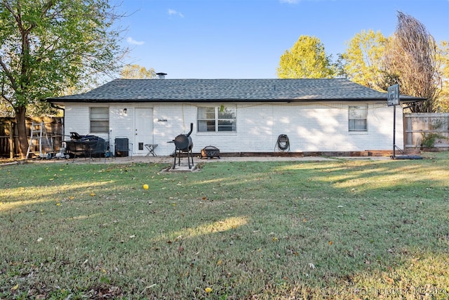 back of house with cooling unit and a lawn