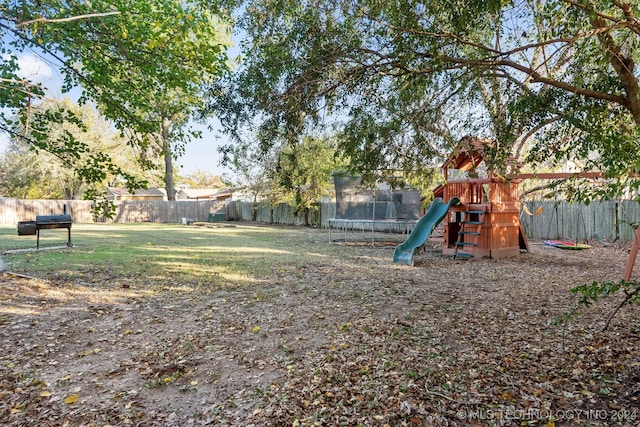 view of yard featuring a playground and a trampoline