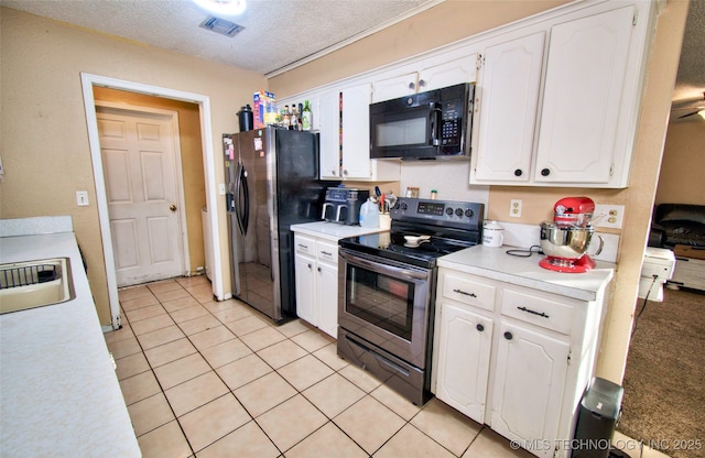 kitchen with stainless steel appliances, white cabinets, a textured ceiling, and light tile patterned flooring