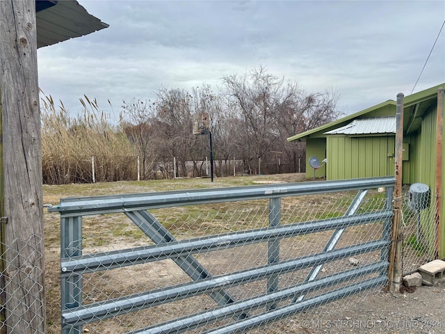 view of gate with an outbuilding