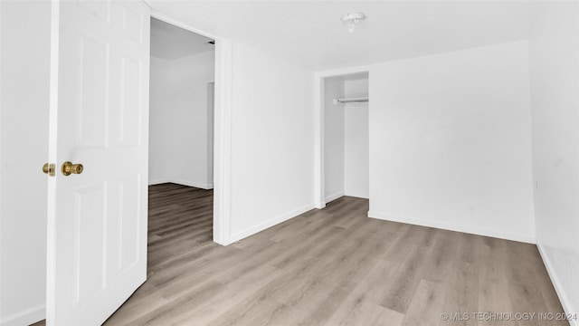 unfurnished bedroom with a closet and light hardwood / wood-style flooring