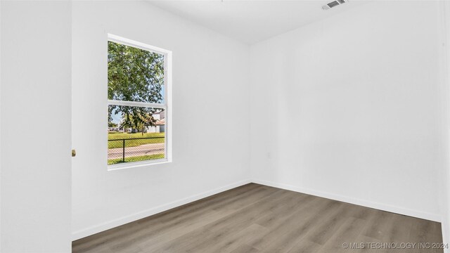 unfurnished room featuring hardwood / wood-style floors and plenty of natural light