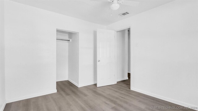 unfurnished bedroom with light wood-type flooring, a closet, and ceiling fan