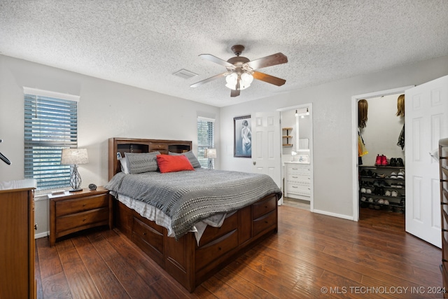 bedroom featuring ensuite bathroom, multiple windows, and dark wood-type flooring