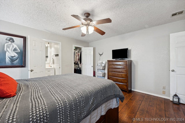 bedroom with dark hardwood / wood-style flooring, a walk in closet, a textured ceiling, ceiling fan, and a closet