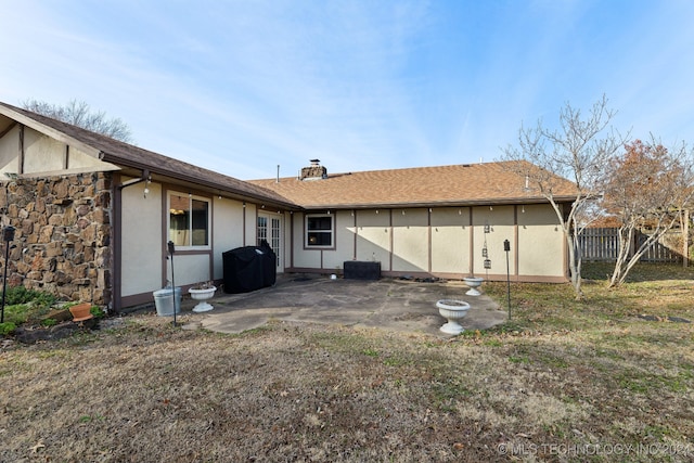 rear view of house featuring a patio area and a yard