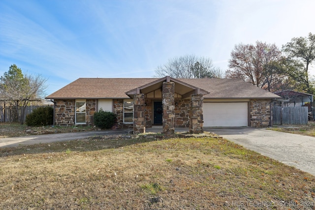 ranch-style home featuring a garage and a front lawn