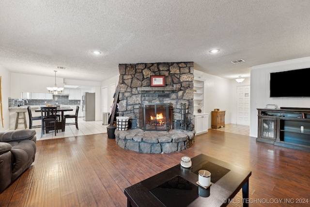 living room featuring a fireplace, light hardwood / wood-style flooring, and a textured ceiling