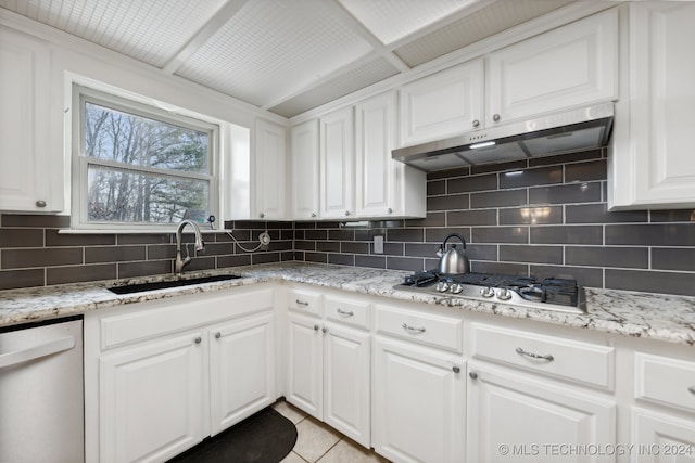 kitchen featuring white dishwasher, stainless steel gas cooktop, sink, light tile patterned floors, and white cabinetry