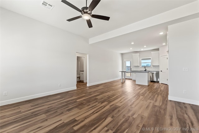 unfurnished living room featuring ceiling fan, dark wood-type flooring, and sink