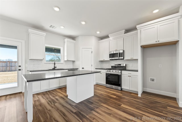 kitchen with white cabinets, a center island, sink, and stainless steel appliances