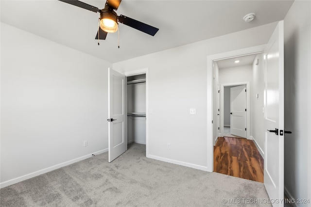 unfurnished bedroom featuring ceiling fan, a closet, and light colored carpet