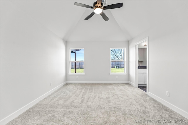 carpeted empty room featuring ceiling fan and lofted ceiling